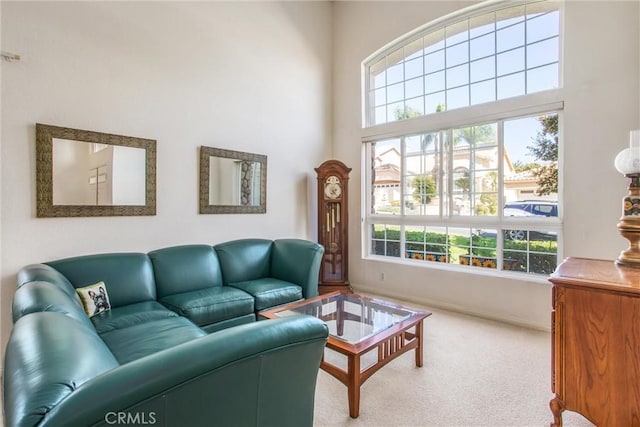 carpeted living room featuring a high ceiling and plenty of natural light