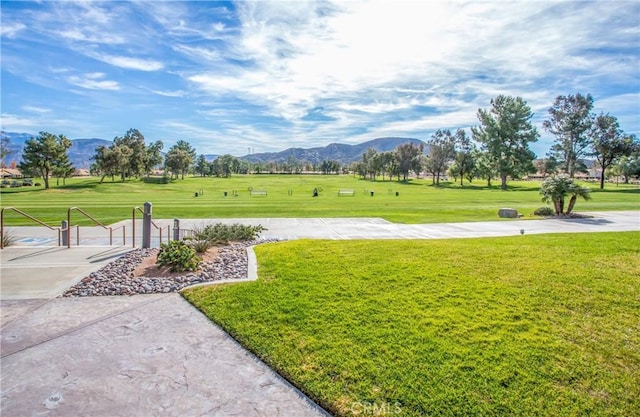 view of community with a mountain view and a lawn