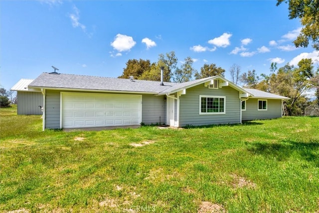 back of house with a lawn, a garage, and driveway