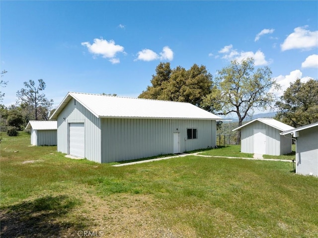 exterior space featuring an outbuilding, a yard, a garage, and a pole building