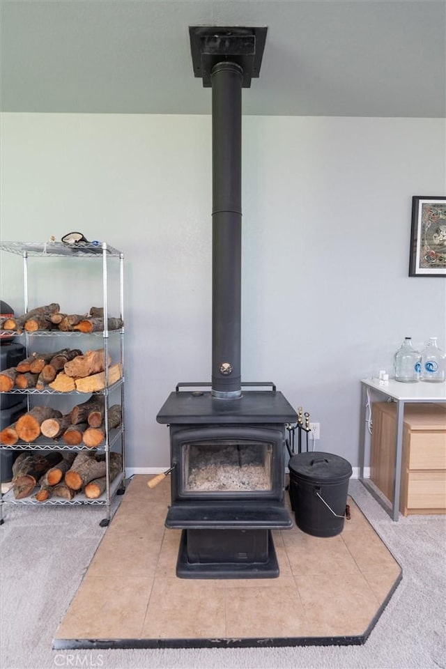 room details featuring baseboards and a wood stove