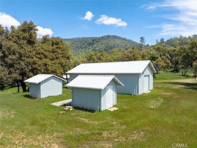 view of outdoor structure featuring an outbuilding and a wooded view