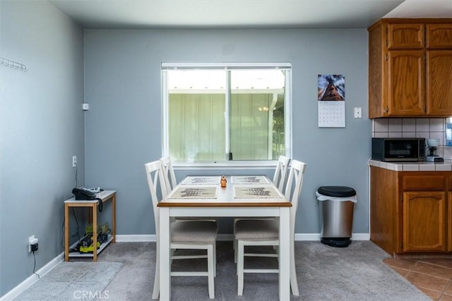 dining area featuring baseboards and carpet flooring