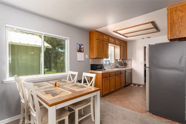 31188 Tera Tera Ranch Rd, North Fork, CA 93643 - kitchen featuring appliances with stainless steel finishes, healthy amount of natural light, brown cabinets, and light tile patterned flooring