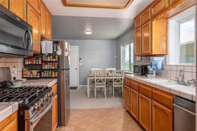 31188 Tera Tera Ranch Rd, North Fork, CA 93643 - kitchen with appliances with stainless steel finishes, tile countertops, light carpet, and backsplash