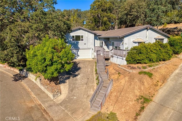 view of front of home featuring a garage, driveway, and stairway