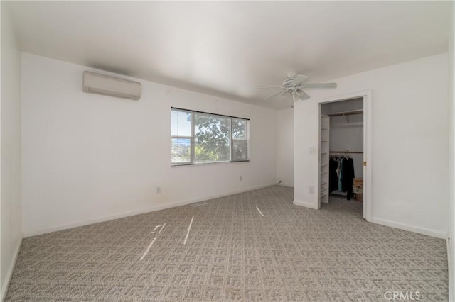 unfurnished bedroom featuring a wall unit AC, a closet, carpet flooring, ceiling fan, and baseboards