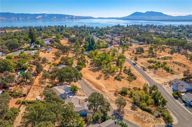 drone / aerial view featuring a water and mountain view