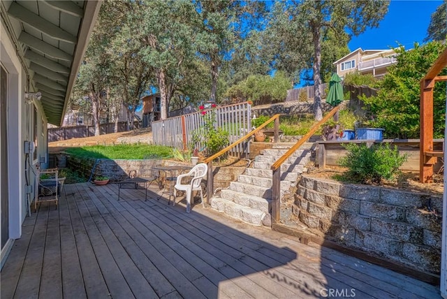 wooden deck with a fenced backyard