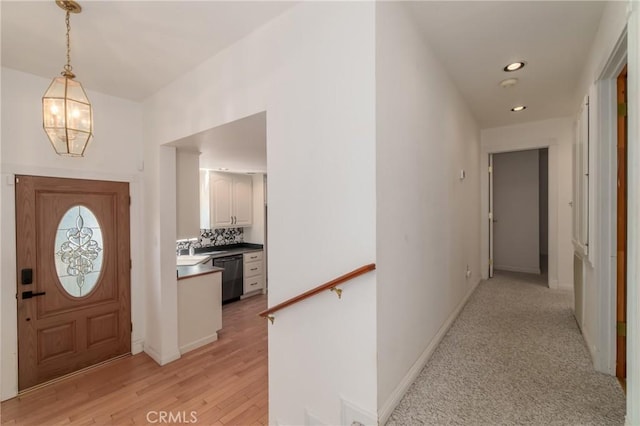 foyer featuring light wood-style floors, baseboards, an inviting chandelier, and recessed lighting