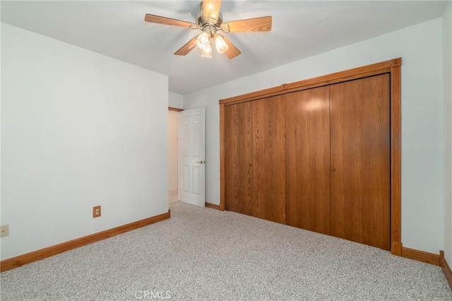 unfurnished bedroom with a ceiling fan, a closet, baseboards, and carpet flooring