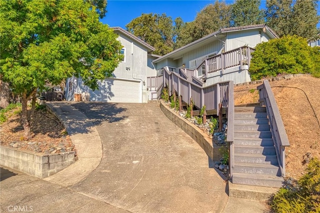 view of front facade featuring a garage, concrete driveway, and stairway