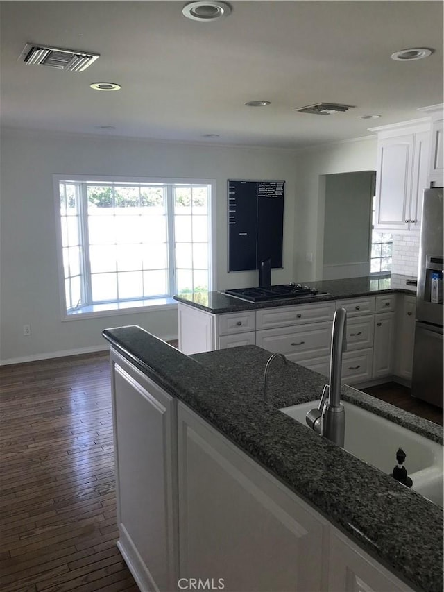 kitchen with dark hardwood / wood-style flooring, sink, white cabinets, and stainless steel appliances