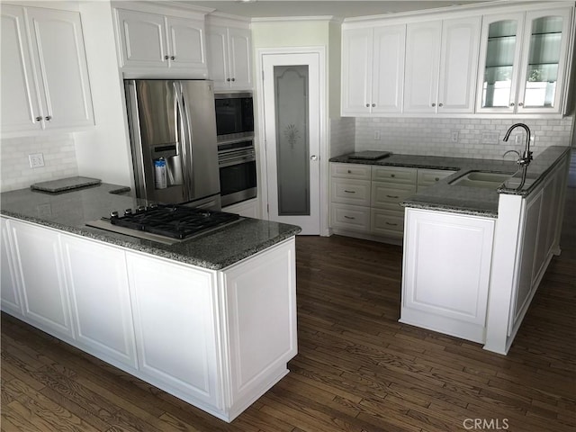 kitchen with kitchen peninsula, sink, white cabinets, and appliances with stainless steel finishes