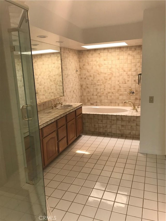 bathroom with tile patterned floors, vanity, and shower with separate bathtub