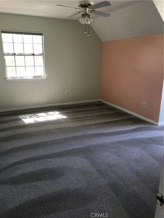 carpeted spare room with vaulted ceiling and ceiling fan