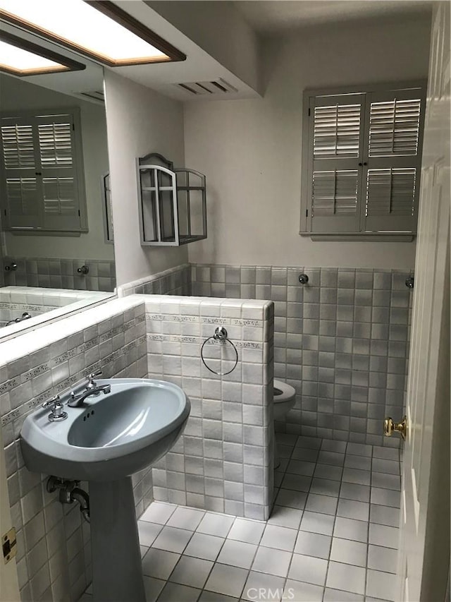 bathroom with tile patterned flooring and tile walls