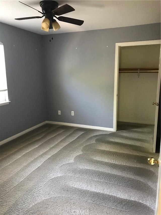 unfurnished bedroom with ceiling fan, a closet, and carpet floors