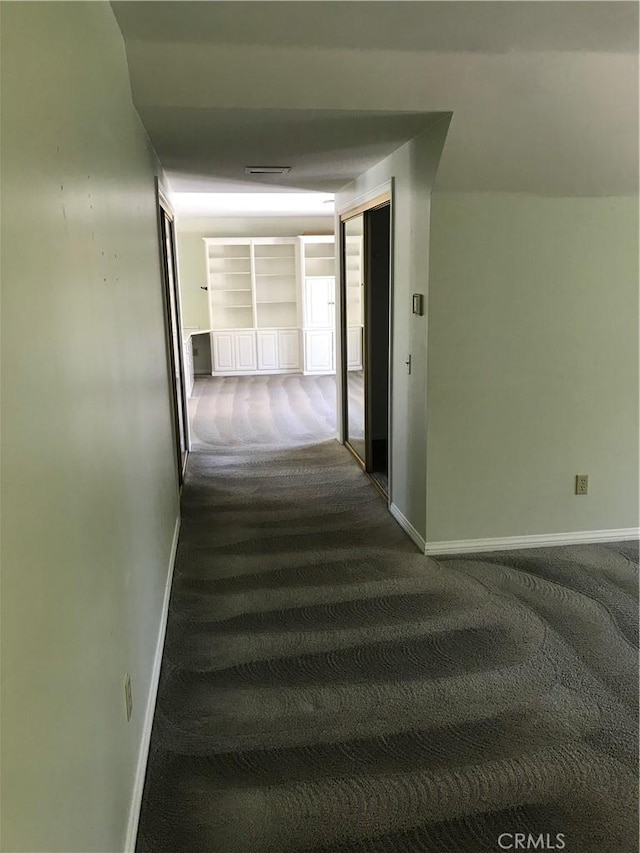 hallway with dark colored carpet