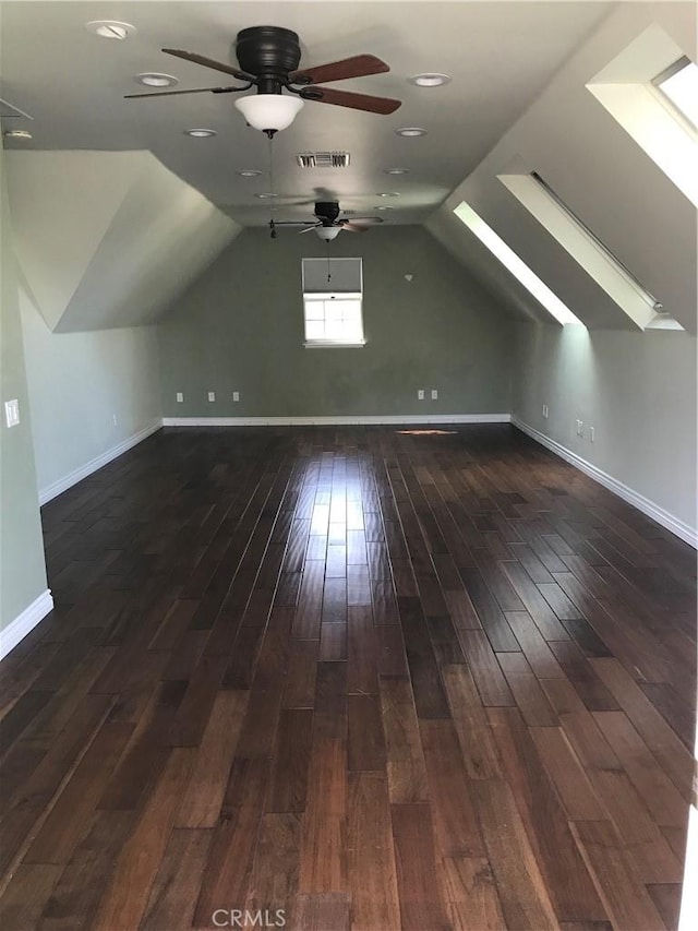 bonus room with lofted ceiling with skylight, dark hardwood / wood-style flooring, and ceiling fan