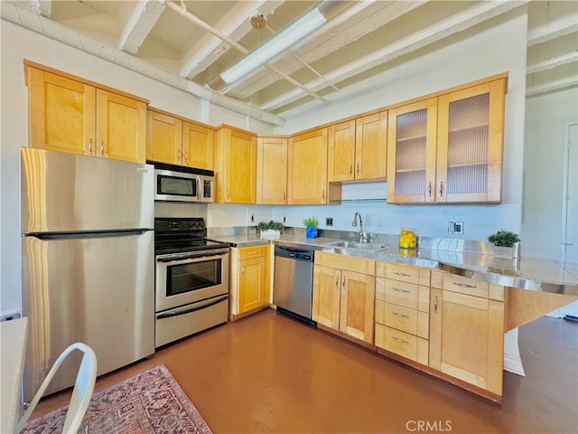 kitchen featuring stainless steel counters, kitchen peninsula, light brown cabinets, stainless steel appliances, and sink