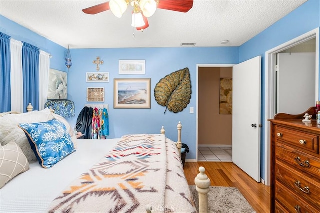 bedroom featuring a textured ceiling, light hardwood / wood-style flooring, and ceiling fan