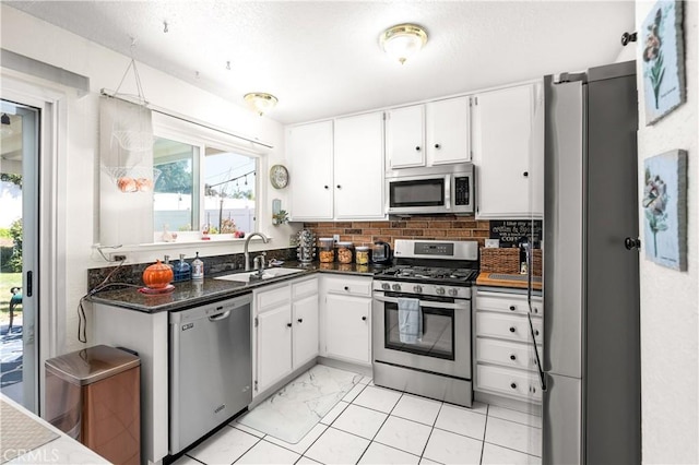 kitchen with white cabinets, stainless steel appliances, tasteful backsplash, and sink