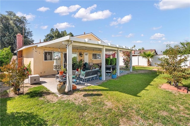 back of property with a lawn, a patio area, and an outdoor hangout area