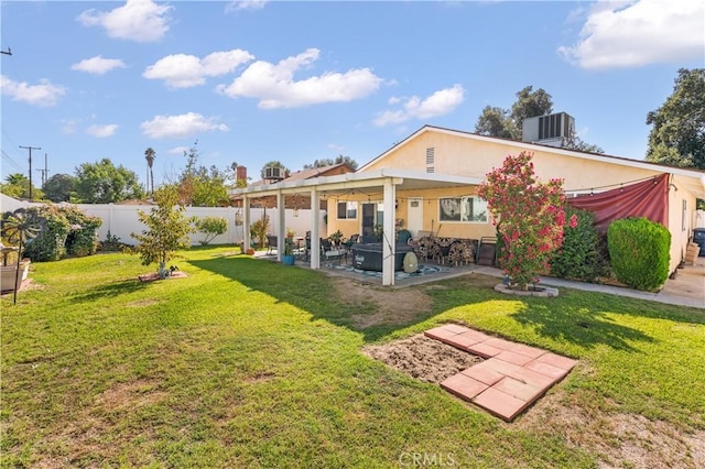 rear view of property featuring a lawn, a patio area, and cooling unit