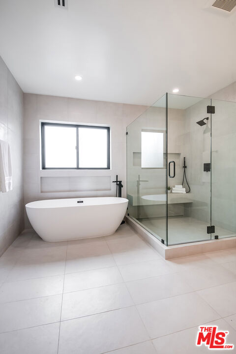 bathroom featuring tile patterned floors and plus walk in shower