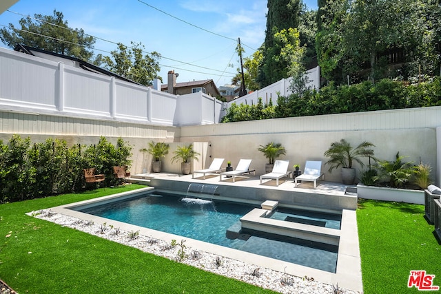 view of pool featuring a lawn, a patio, an in ground hot tub, and pool water feature