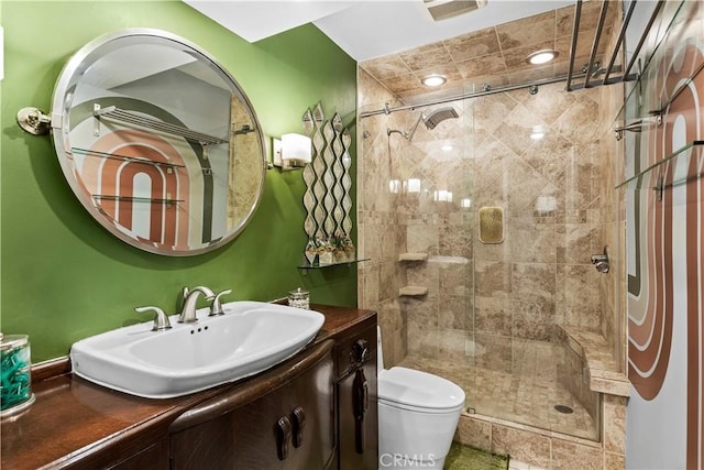 bathroom with an enclosed shower, vanity, and toilet