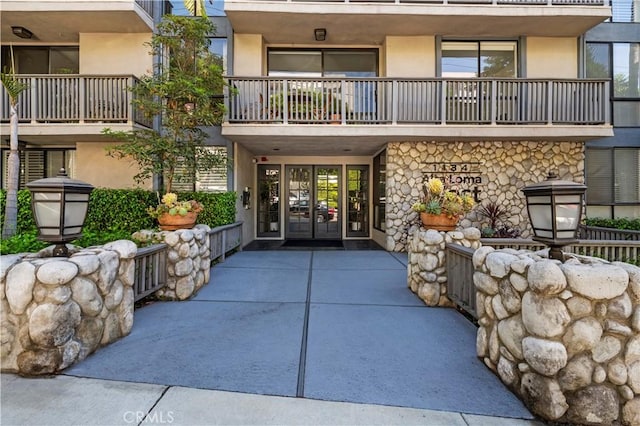 entrance to property featuring french doors and a balcony