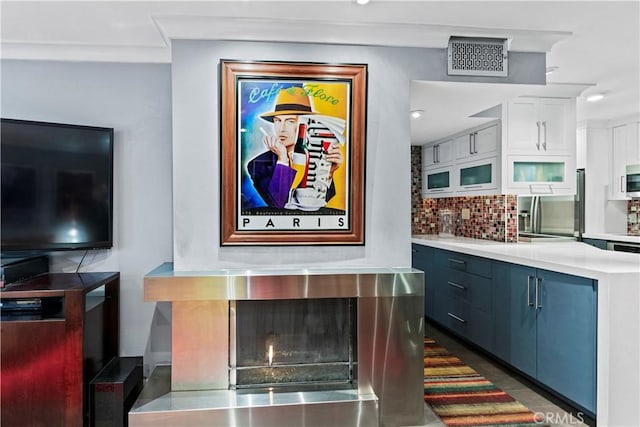 kitchen featuring backsplash, blue cabinets, white cabinetry, and stainless steel appliances