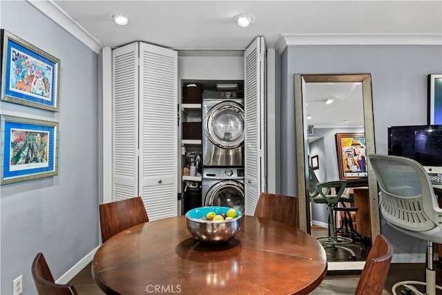 dining space with wood-type flooring, stacked washer and clothes dryer, and ornamental molding