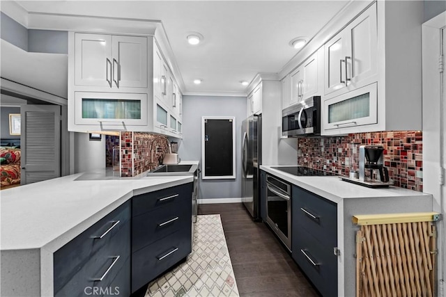 kitchen with decorative backsplash, sink, white cabinetry, dark wood-type flooring, and stainless steel appliances