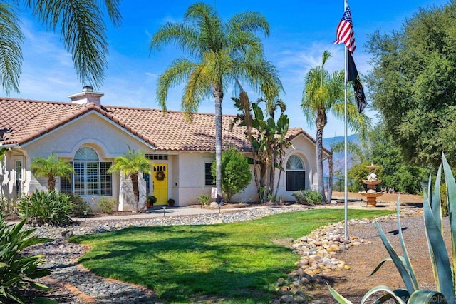 mediterranean / spanish home with a front yard