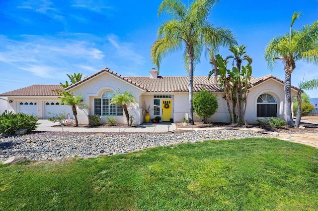 mediterranean / spanish home featuring a garage and a front yard