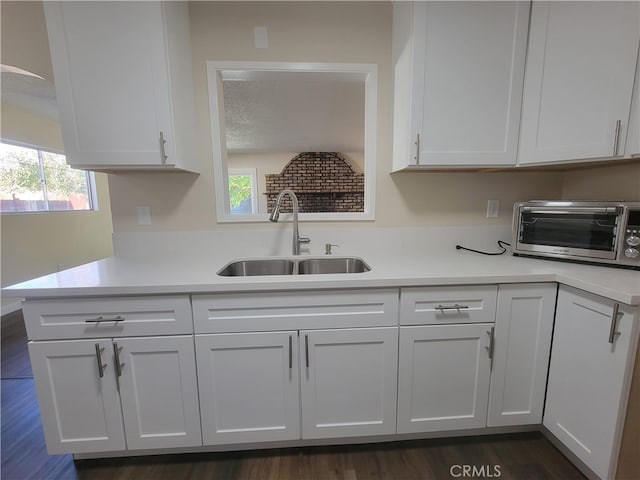 kitchen featuring white cabinetry, sink, and dark hardwood / wood-style flooring