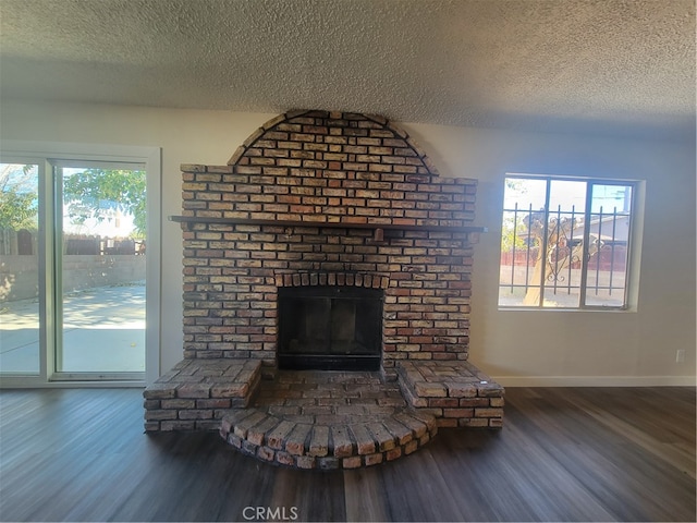 room details featuring a brick fireplace, a textured ceiling, and hardwood / wood-style floors