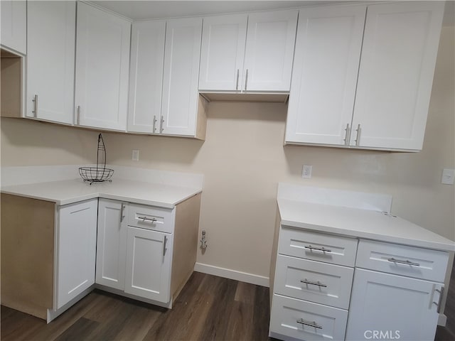 kitchen with dark wood-type flooring and white cabinetry