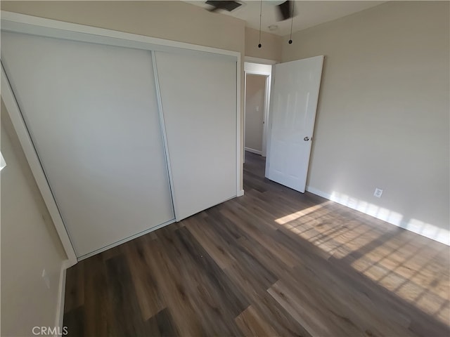 unfurnished bedroom with a closet and dark hardwood / wood-style flooring