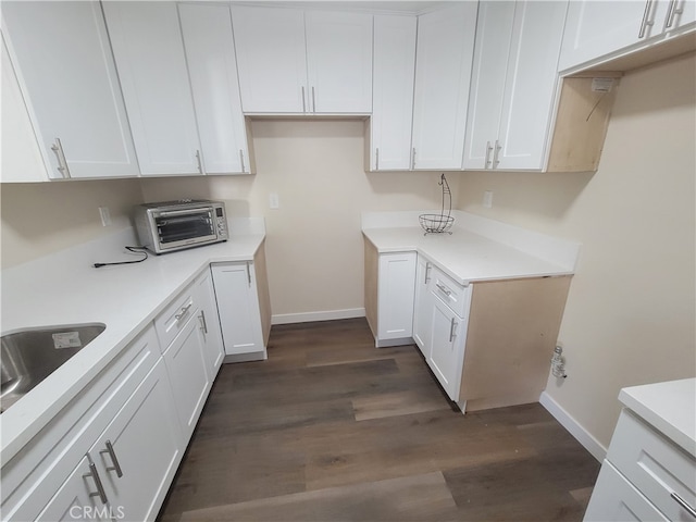 kitchen with white cabinetry, sink, and dark wood-type flooring