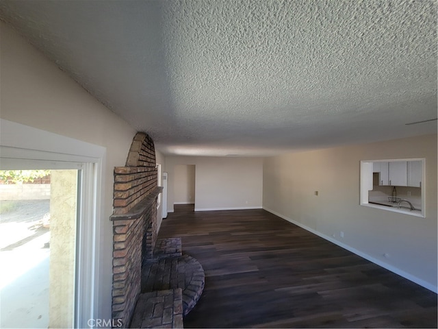 unfurnished living room featuring a textured ceiling, a fireplace, and dark hardwood / wood-style floors