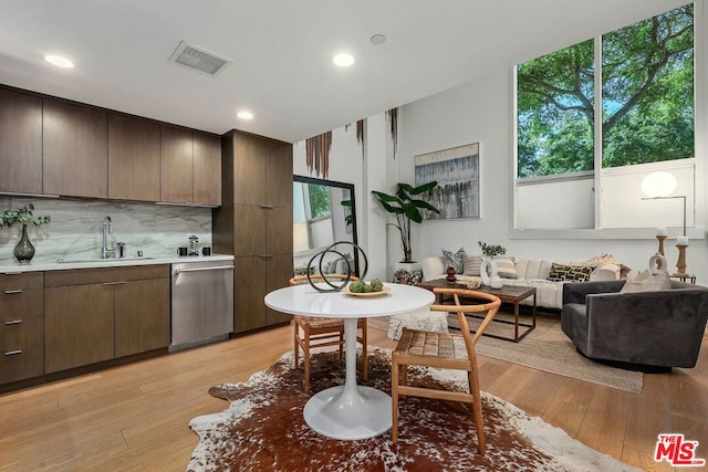 kitchen featuring a healthy amount of sunlight, light hardwood / wood-style floors, sink, and dishwasher