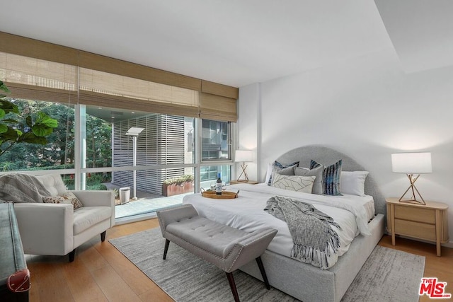 bedroom with wood-type flooring and multiple windows