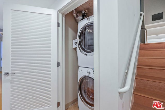 washroom with stacked washing maching and dryer