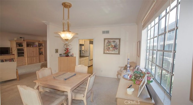 dining space with crown molding, light carpet, and a wealth of natural light