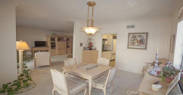 carpeted dining room with crown molding