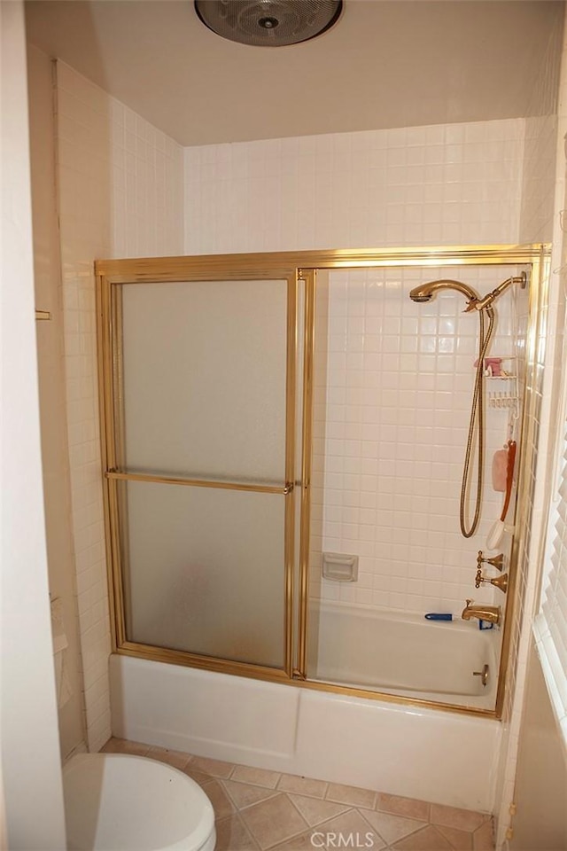 full bath featuring bath / shower combo with glass door, tile patterned floors, and toilet